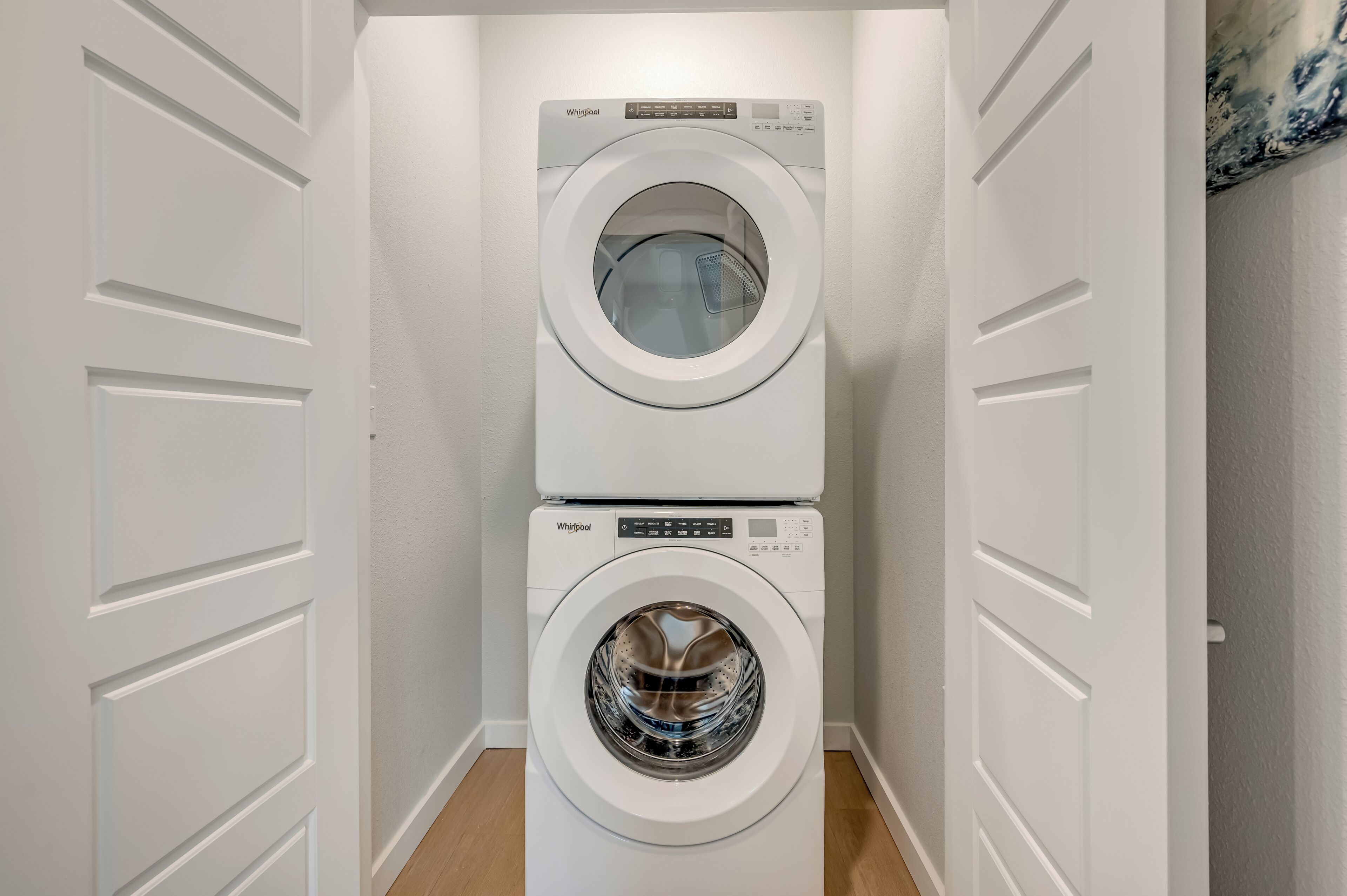 Une petite buanderie équipée de deux machines à laver Whirlpool superposées.