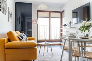 Un salon moderne avec un canapé, une table à manger et un téléviseur.