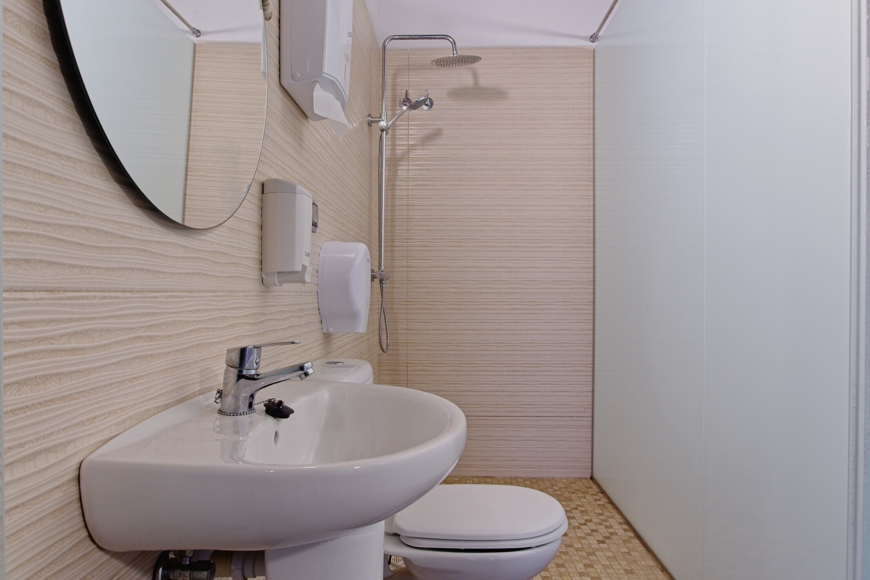 Een badkamer met een wastafel, toilet en douche.