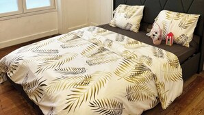 Ein Schlafzimmer mit Bett, Fenster, Tür und Wandtapete mit Muster.