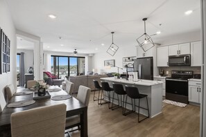 A modern kitchen with a central island, black chairs, and a dining area with a table and chairs. - Main Channel Views, Resort Pools & Boat Slip at Topsider's 19MM (Osage Beach)