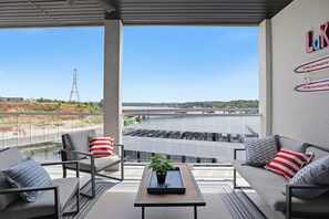 A balcony with a sofa, chairs, a tray table, and a potted plant. - Main Channel Views, Resort Pools & Boat Slip at Topsider's 19MM (Osage Beach)