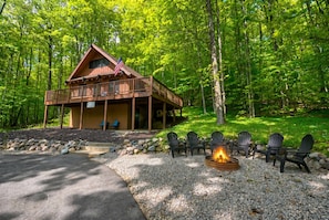 A lodge with a deck, outdoor seating, and a fire pit.