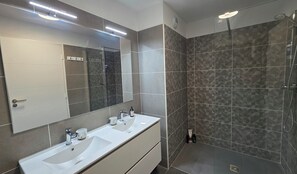A modern bathroom with two sinks, a large mirror, and a shower area. - Bright, new apartment with a terrace 3* (Briançon)