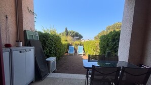 An outdoor patio with a table and chairs, a refrigerator, and a potted plant. - Garden studio with terrace, 600m from the port (Saint-Raphaël)