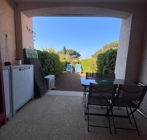 An outdoor patio with a table and chairs, a refrigerator, and a potted plant. - Garden studio with terrace, 600m from the port (Saint-Raphaël)