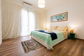 Una camera da letto con un letto, una lampada da comodino, un tappeto e un quadro appeso al muro.