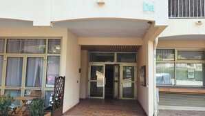 Une entrée d’immeuble avec un porche abrité, un escalier menant à l’intérieur et une enseigne avec la lettre « Da ».