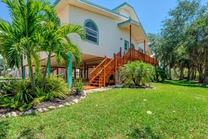 A two-story house with a wooden staircase leading to a covered porch. - Blue Bayou B (Fort Myers Beach)