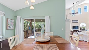 A dining area with a wooden table, white chairs, and a central decorative piece. - Blue Bayou B (Fort Myers Beach)