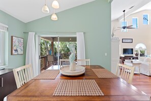 A dining area with a wooden table, white chairs, and a central decorative piece. - Blue Bayou B (Fort Myers Beach)