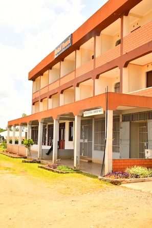 A multi-story building with a sign reading 'TUSKEGATE ELECTRICAL & SANITARY WARES' and a covered entrance area.