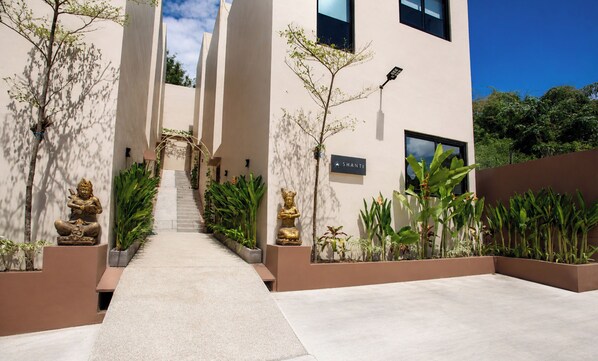 A modern building with a central staircase, potted plants, and a sign reading 'SHANTI'. - Modern 1 bedroom loft - Shanti Loft 6 (Kabupaten Badung)