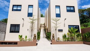 Edificio moderno con escalera central, diseño simétrico y plantas de exterior.