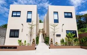 A modern building with a central staircase, symmetrical design, and outdoor plants. - Modern 1 bedroom loft - Shanti Loft 6 (Kabupaten Badung)