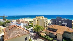 A coastal town with buildings, a beach, and the sea. - Penthouse Ponta da Areia | Sea & Garage (Portimão)