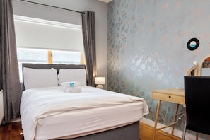 A hotel room with a bed, a desk, and a chair. - Stylish 2BR | Walk to Temple Bar & Dublin Castle (Temple Bar)
