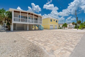A two-story house with a covered porch, a staircase, and a driveway. - Palermo Paradise (Fort Myers Beach)