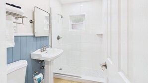 Une salle de bain avec une douche, un lavabo et des toilettes.