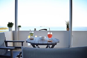 A balcony with a table, two drinks, a bowl of snacks, and potted plants. - Villa Ariadne, Divine Sea Views, Private Pool, Furnished Terrace, Andros (Andros)