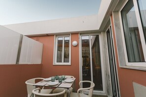 Ein Essbereich mit Tisch, Stühlen, einer Schiebeglas-Tür und einem Fenster.