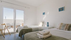 Ein Hotelzimmer mit zwei Betten, einem Balkon und Blick zum Himmel.