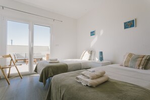 Ein Hotelzimmer mit zwei Betten, einem Balkon und Blick zum Himmel.