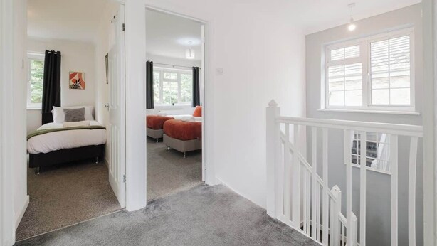 A bedroom with a bed, a window, and a door leading to another room. - Spacious 4 Bedroom Home With Free Parking (Northampton)