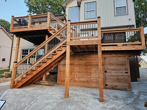 Una casa de dos pisos con un balcón de madera y una escalera.