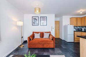 A modern living room with a sofa, a floor lamp, and two framed artworks on the wall. - Stylish 2 BDR APT Free Parking Liverpool (Liverpool)