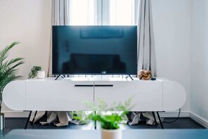 A modern living room with a flat-screen TV, white entertainment unit, and a potted plant. - Stylish 2 BDR APT Free Parking Liverpool (Liverpool)