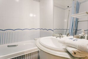 A bathroom with a bathtub, a sink, a mirror, and a shower. - Best Houses 32 - Dunas Beach Peniche (Peniche)