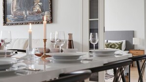 A dining area with a table set for two, a candle, and a painting above. - Home Spa | Balcony | EV Parking | 200m Tram | 3BR (Helsinki)