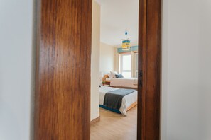 Ein Schlafzimmer mit Bett, Nachttisch, Lampe und Fenster.