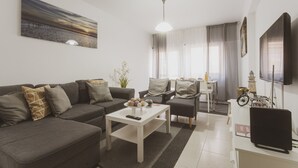 Een moderne woonkamer met een bank, salontafel en tv-meubel.