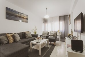 Ein modernes Wohnzimmer mit Sofa, Couchtisch und TV-Möbel.