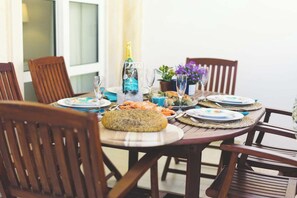 A dining table set with plates, glasses, and a bottle of champagne. - Best Houses 36 - Baleal Surf Village (Baleal)