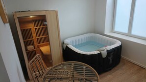 Una stanza con un armadio in legno, una sedia in vimini e una piccola piscina gonfiabile.