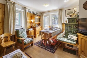 Ein gemütliches Zimmer mit Holzmöbeln, einem Esstisch und einem Fernseher.