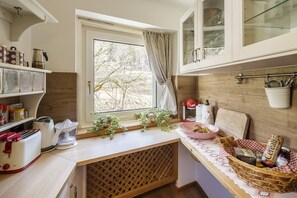 Eine Küche mit Fenster, Toaster, Wasserkocher, Spüle und einer Arbeitsfläche mit einem Brotkorb.