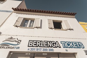 Un edificio con un cartel que indica 'BERLENGA TICKETS' y un número de teléfono.