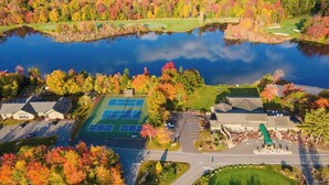 An aerial view of a residential area with a tennis court, a golf course, and a body of water. - Bluewood Escape: Sauna, Hot Tub, Game Room (Tobyhanna)