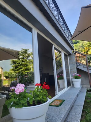 A modern house with a covered porch, large windows, and potted plants.