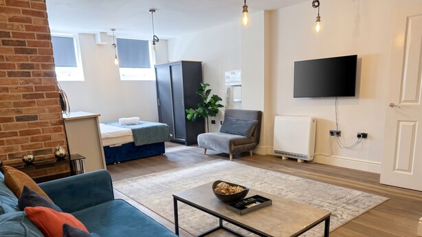 Ein modernes Wohnzimmer mit einer Couch, einem Couchtisch, einem Fernseher und einer Heizung.