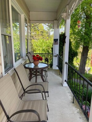A covered porch with a table and chairs, a potted plant, and a railing. - Cozy 1-Full bed and Private Bath in tranquil Jim Thorpe with AC (Jim Thorpe)