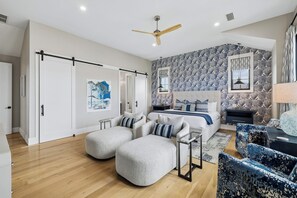 A modern bedroom with a bed, two ottomans, a desk, and a chair. - Casa Amor|Easy Beach Access|Private Pool|Golf Cart (Seagrove Beach)