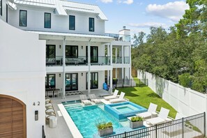 A two-story residential building with a swimming pool, outdoor seating, and a fenced yard. - Casa Amor|Easy Beach Access|Private Pool|Golf Cart (Seagrove Beach)
