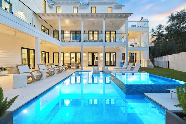 A two-story house with a swimming pool, outdoor seating, and a well-lit balcony. - Casa Amor|Easy Beach Access|Private Pool|Golf Cart (Seagrove Beach)