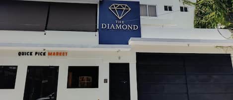 Un edificio con un cartel que dice 'The Diamond' y la entrada a 'Quick Pick Market'.