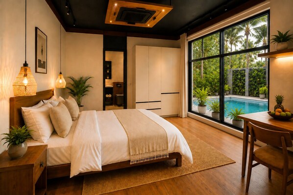A bedroom with a large bed, bedside lamps, a view of a swimming pool, and a dining area with a table and chairs. - TUNA Hiriketiya King Room with Pool View 822 (Dickwella)